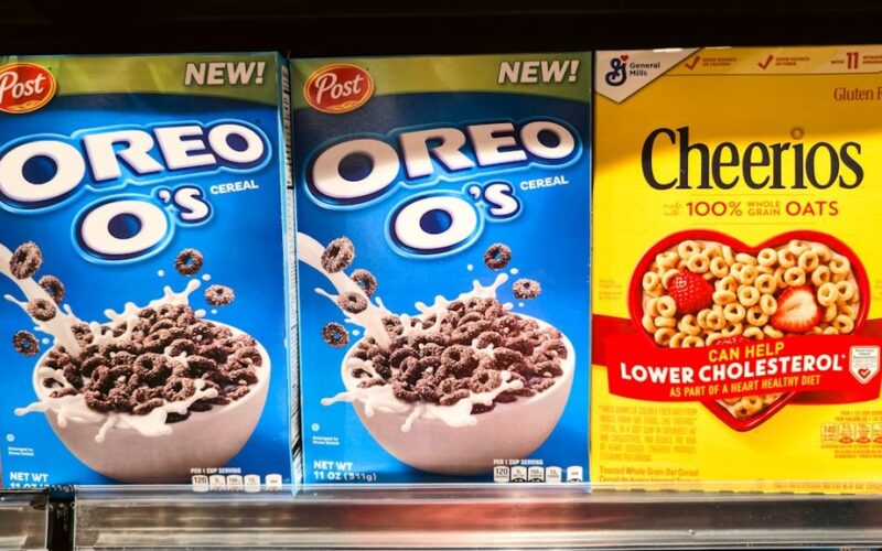 Cereal - Photograph of stacked cereal boxes featuring Oreo O’s and Cheerios, two popular breakfast cereals found in grocery stores. The image captures the colorful packaging and branding of these iconic products, often enjoyed with milk as part of a morning meal or snack. Perfect for illustrating breakfast culture, retail displays, and food marketing.