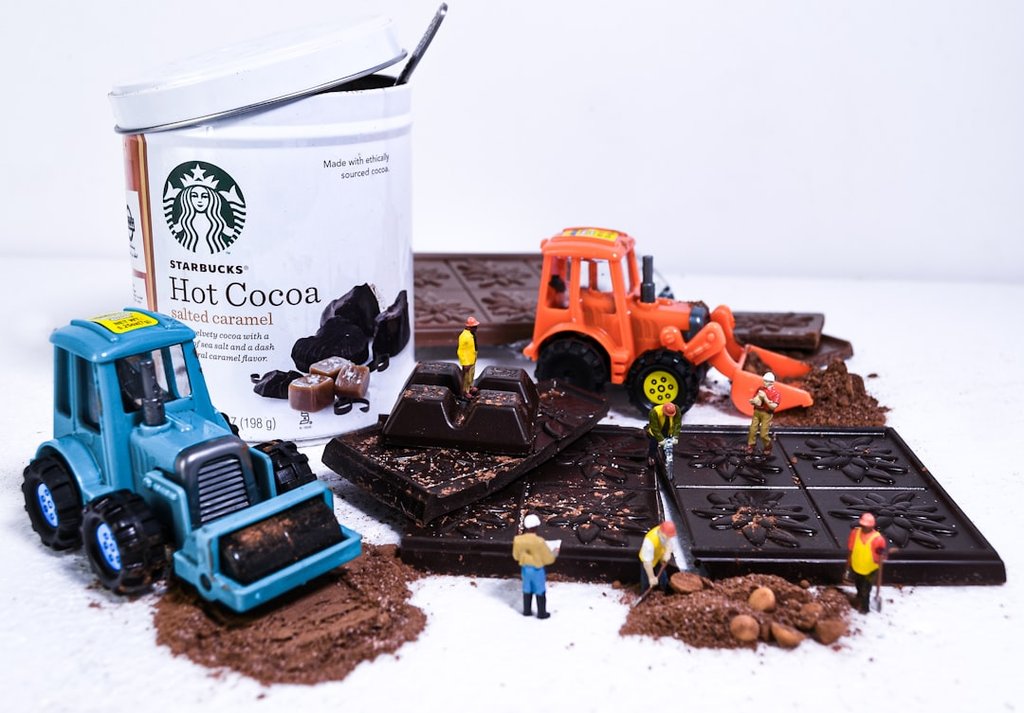 Starbucks - a container of hot cocoa next to a couple of toy tractors